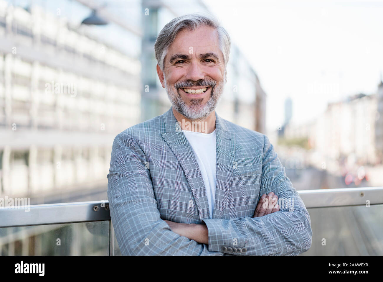 Portrait of smiling fashionable mature businessman outdoors Stock Photo