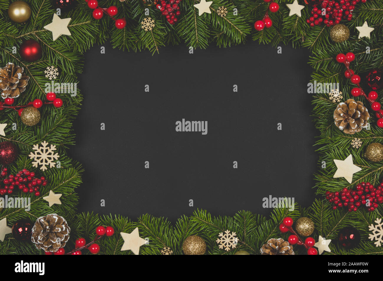 Natural fir Christmas tree border frame with decor on black, copy space ...