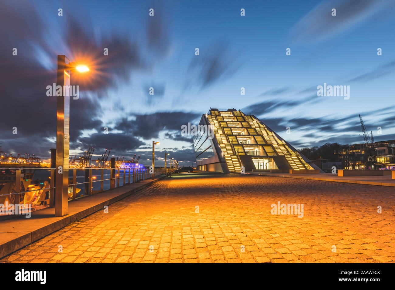 Diminishing perspective of footpath by Dockland building against sky at dusk, Hamburg, Germany Stock Photo