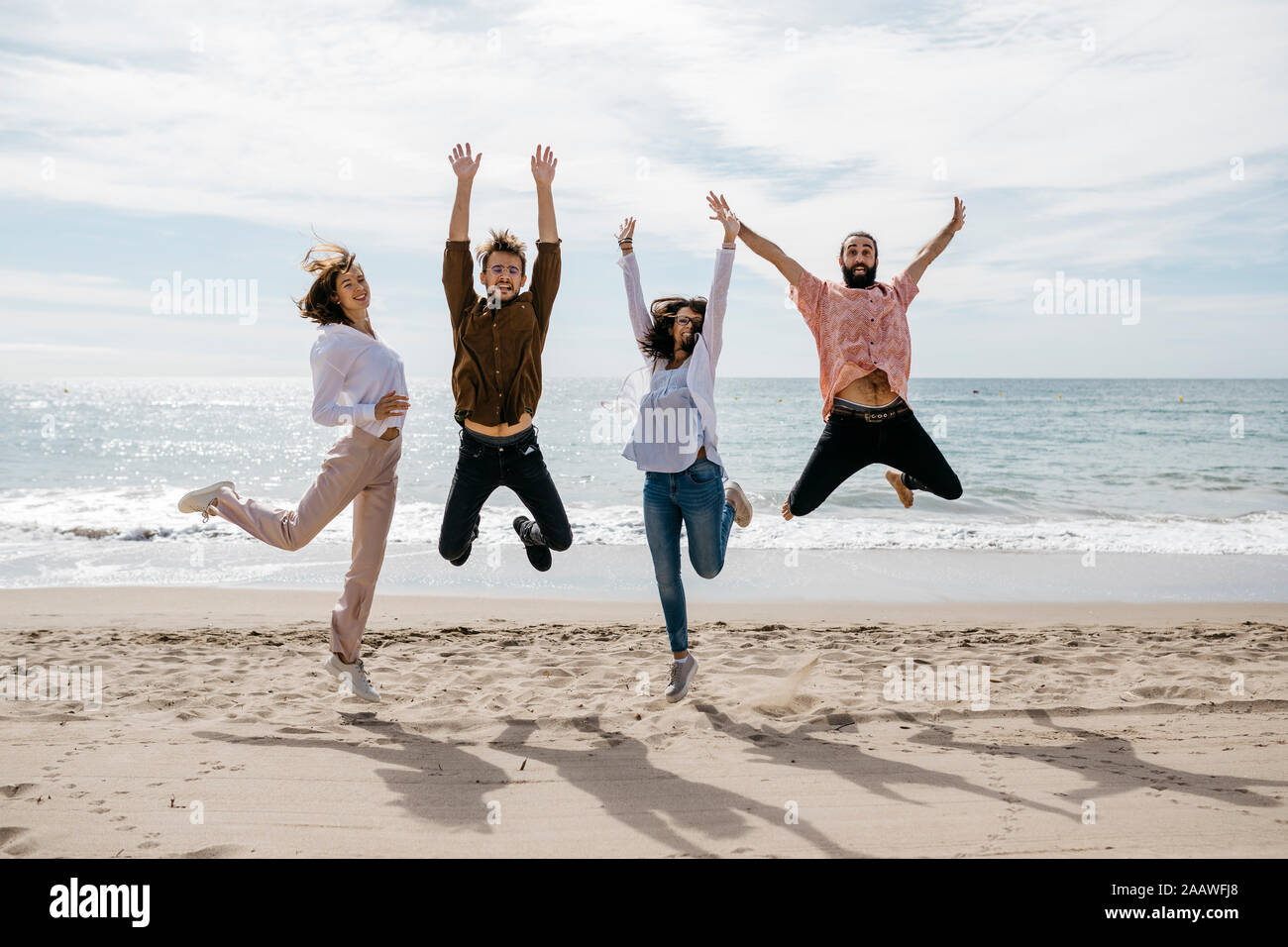 Exuberant friends jumping on the beach Stock Photo