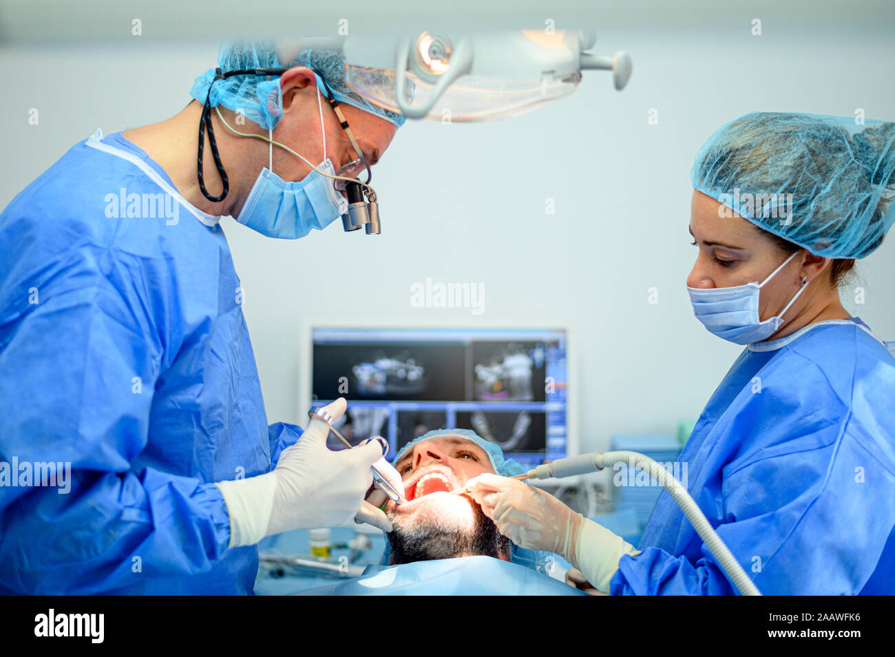 Dental surgeon and assistant work putting dental implant Stock Photo