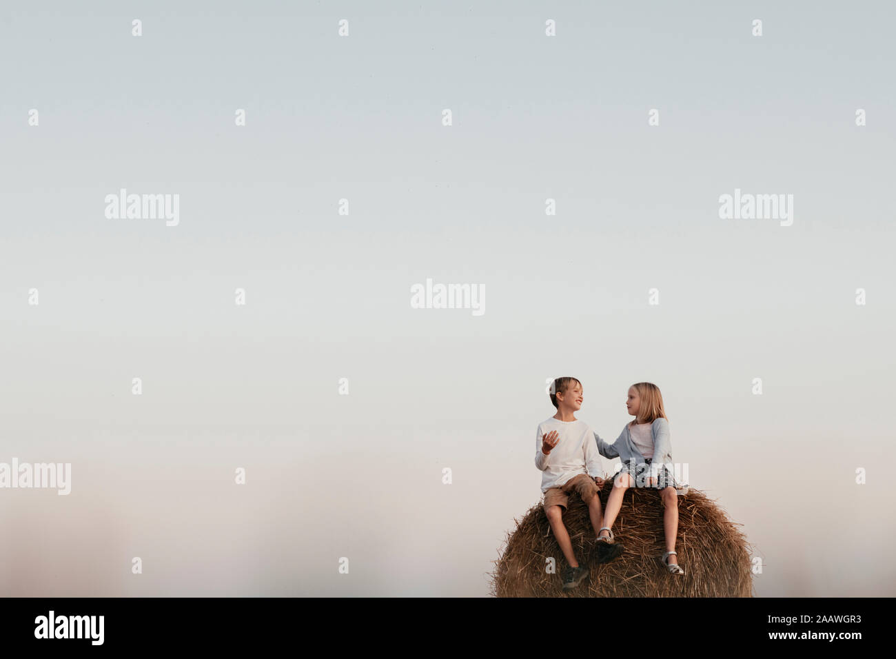 Two kids sitting on the haystack Stock Photo