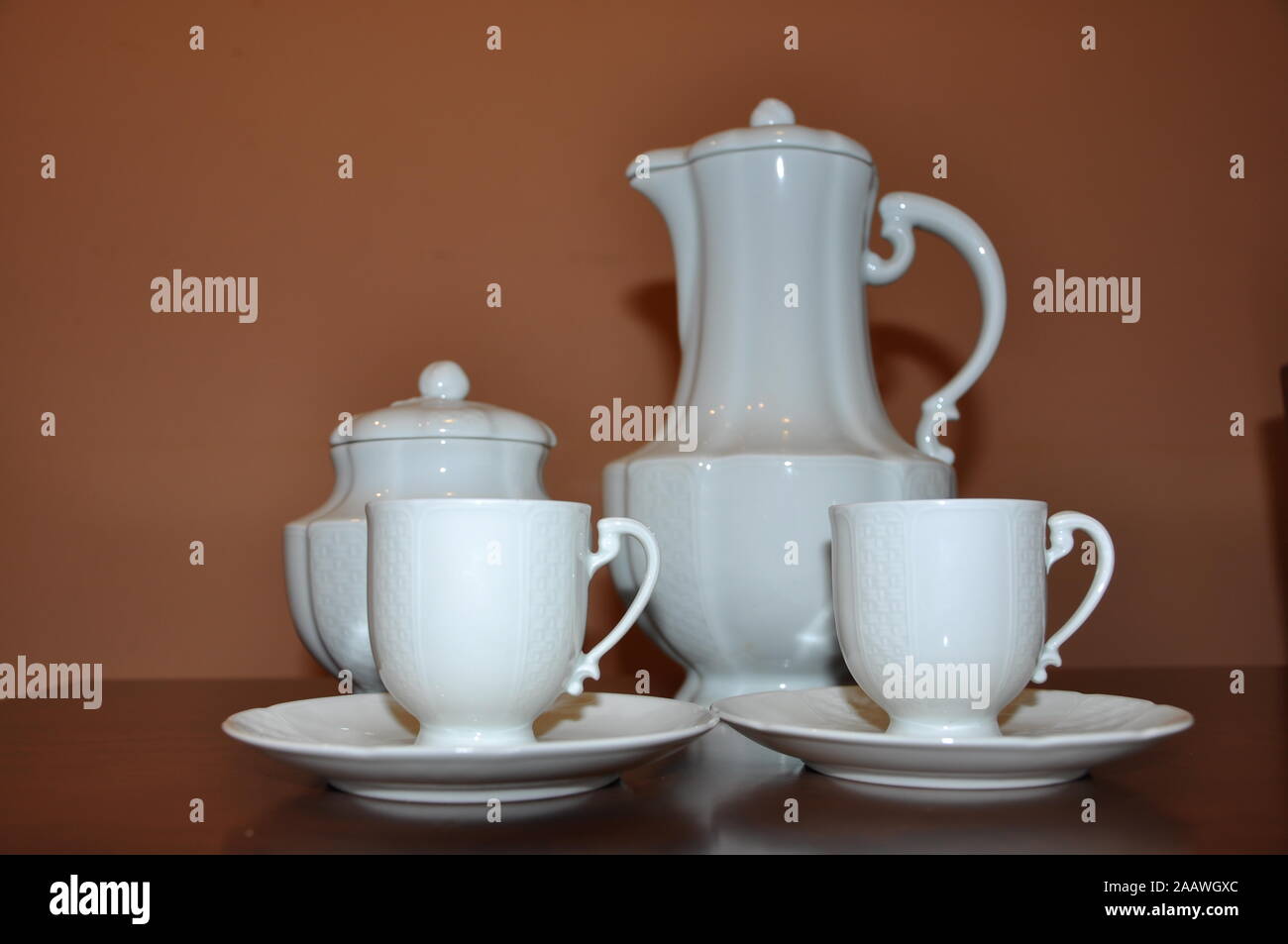 Elegant white porcelain coffee set on brown wooden table Stock Photo