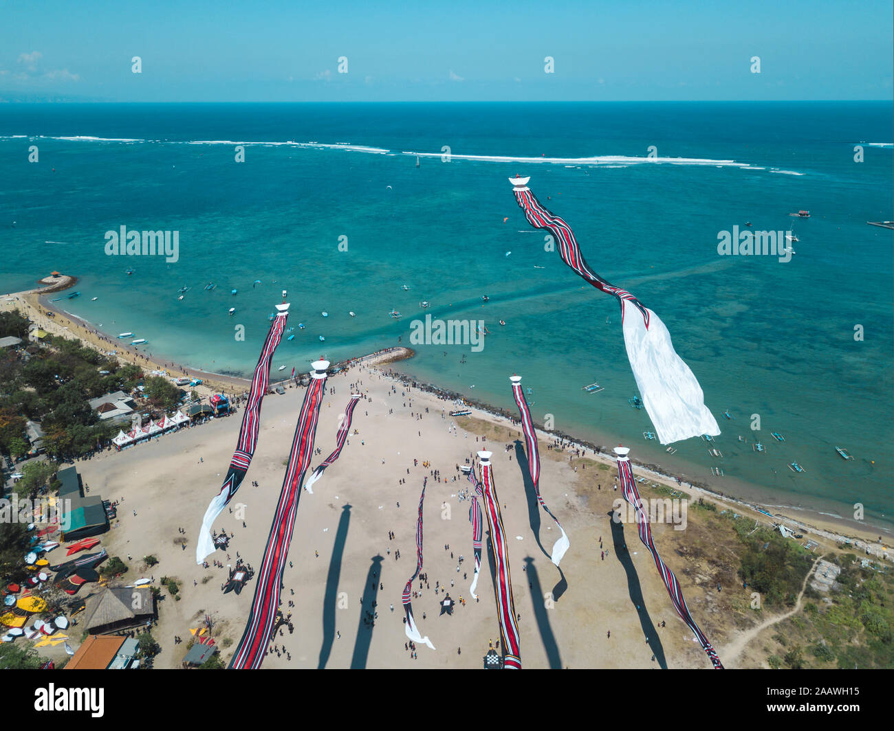 Aerial view of kites flying at beach against blue sky during festival