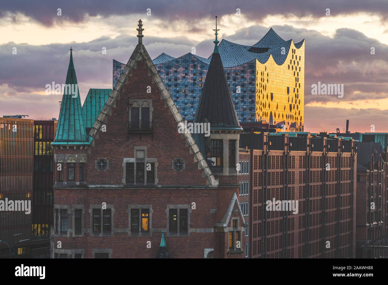 View of Elbphilharmonie and Speicherstadt against cloudy sky during sunset in Hamburg, Germany Stock Photo