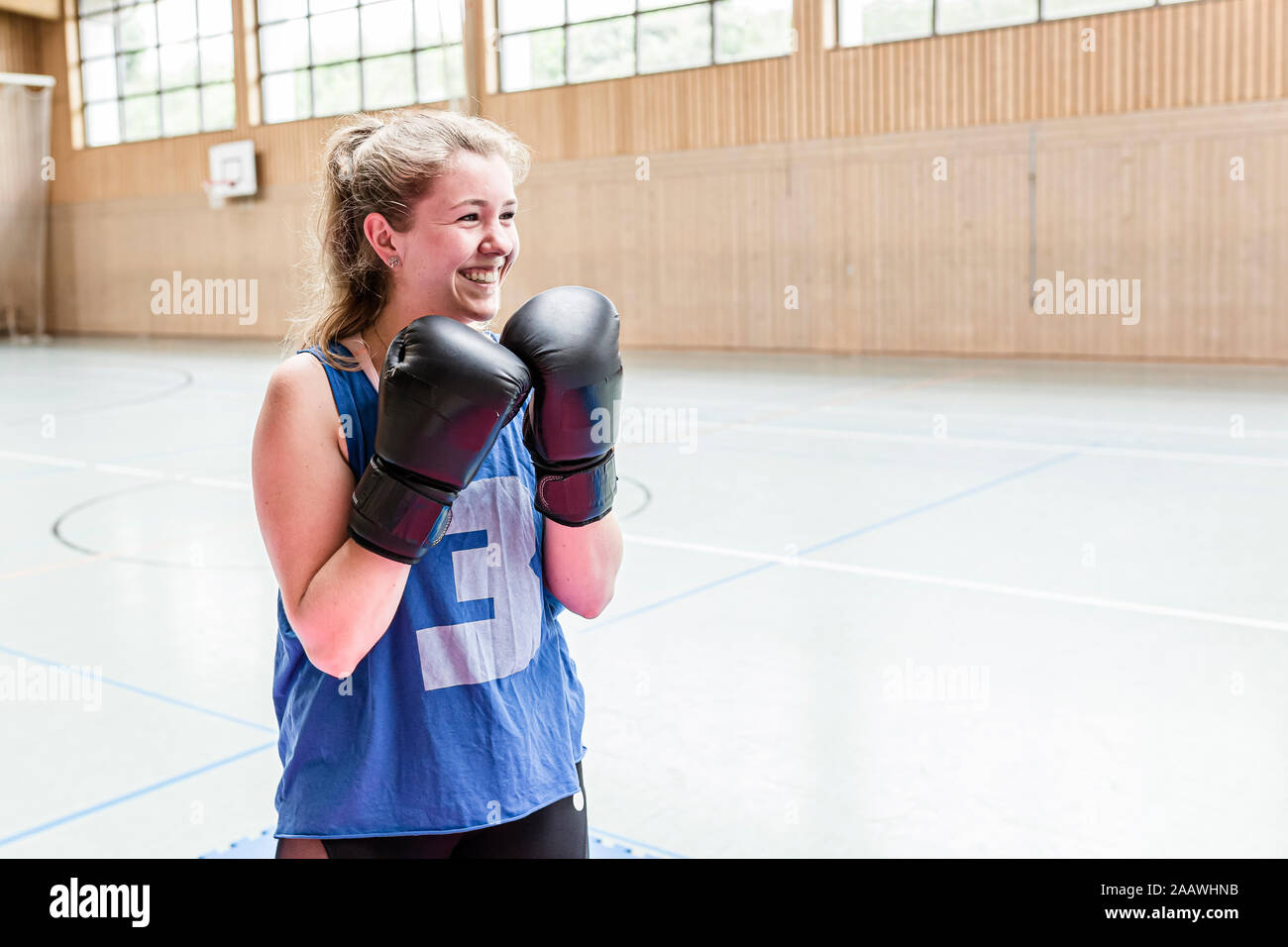 Happy female boxer in sports hall Stock Photo