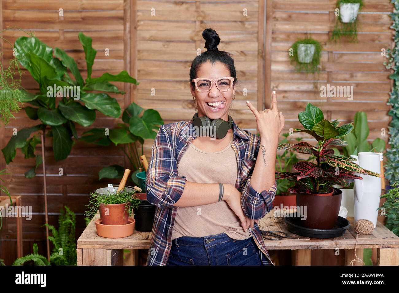 Portrait of a happy young woman gardening on her terrace Stock Photo