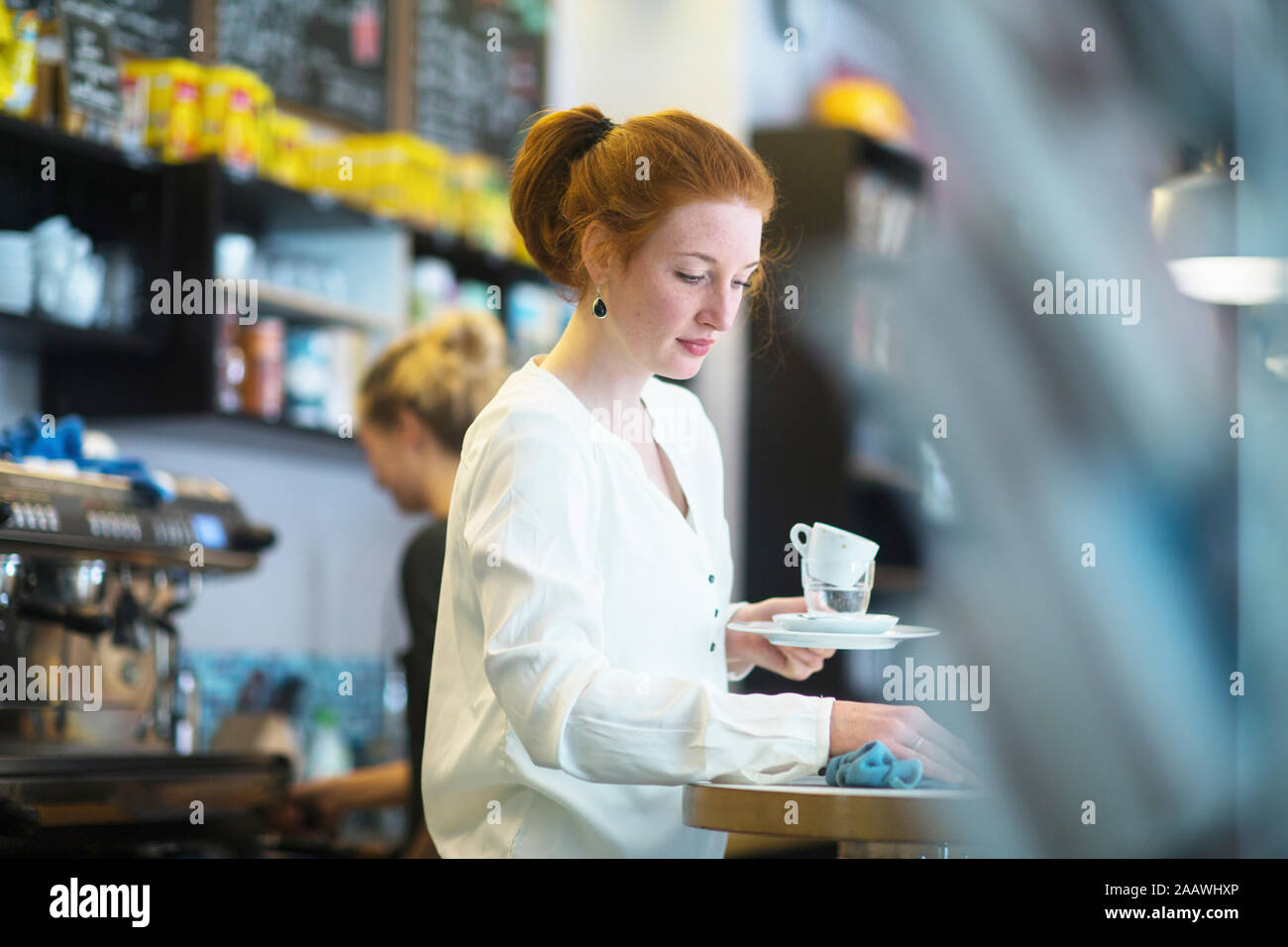 Young woman working in coffee shop Stock Photo