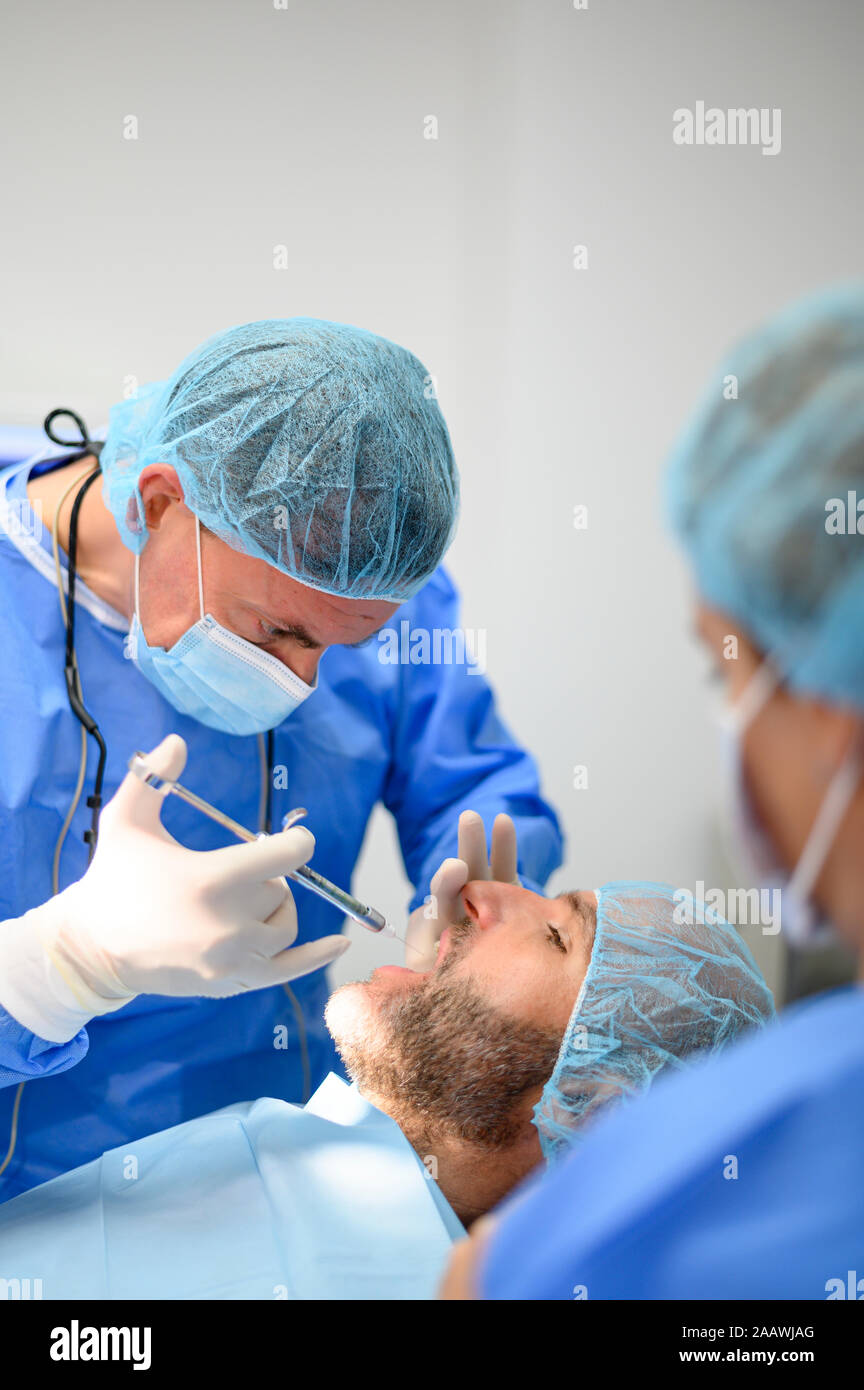 Dentist surgeon injecting anesthesia to patient Stock Photo Alamy