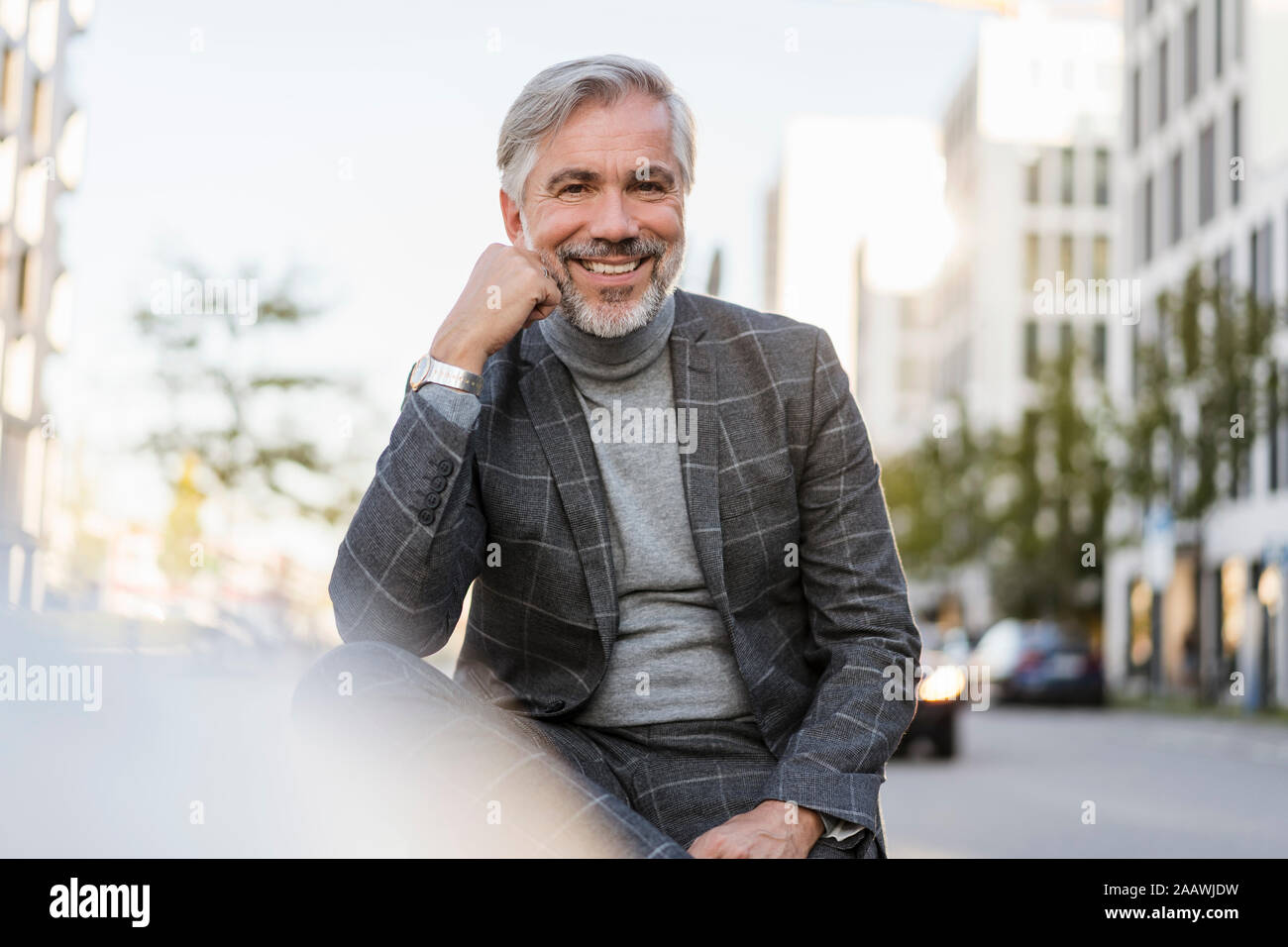 Portrait of smiling fashionable mature businessman in the city Stock Photo