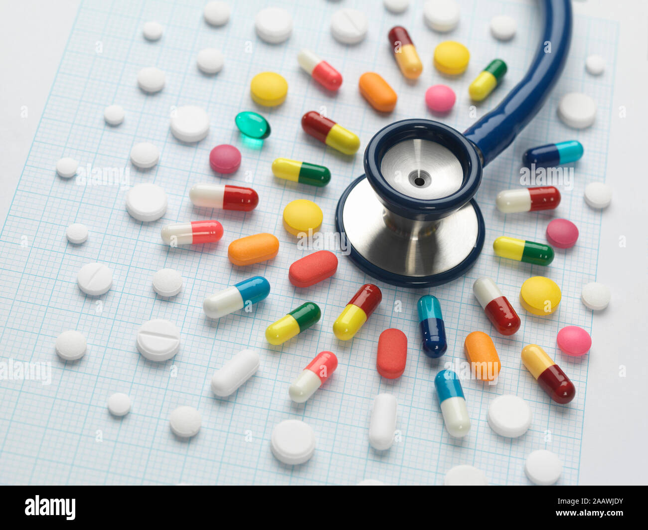 High angle view of colorful medicines arranged around stethoscope on graph paper Stock Photo