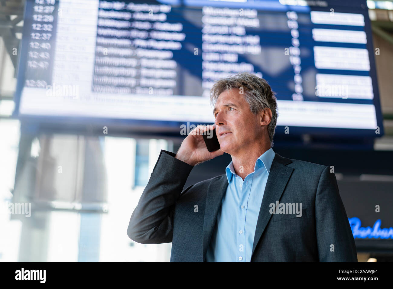Mature businessman on the phone at the station Stock Photo
