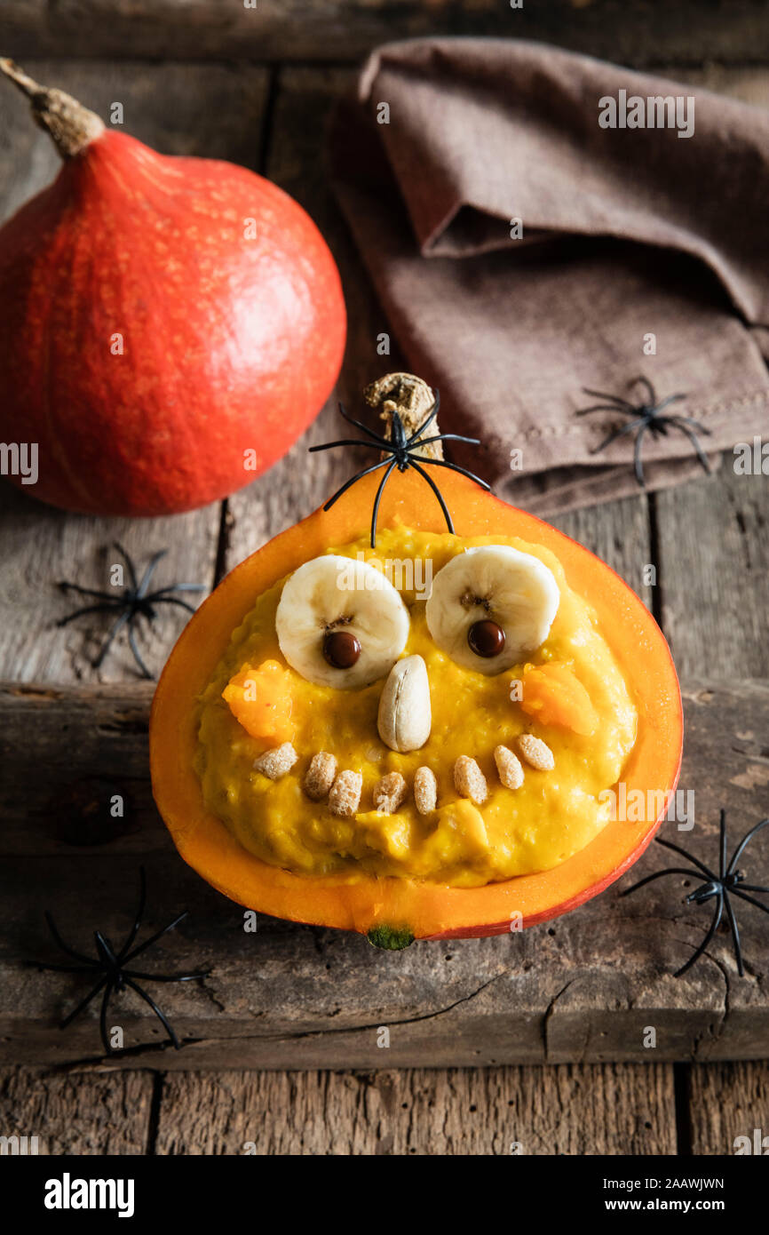 High angle view of pumpkin with anthropomorphic face on table during Halloween Stock Photo