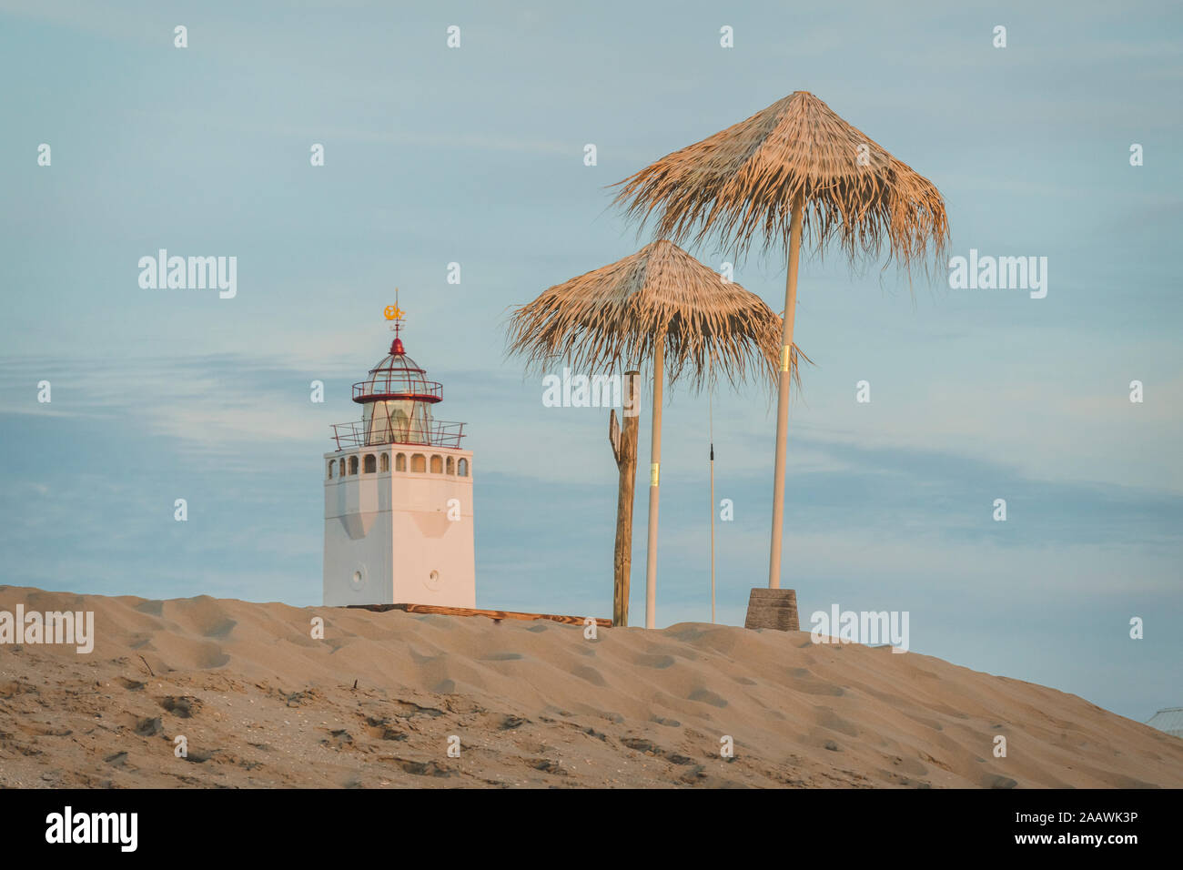 Netherlands, South Holland, Noordwijk, lighthouse and sun shades on sandy beach Stock Photo