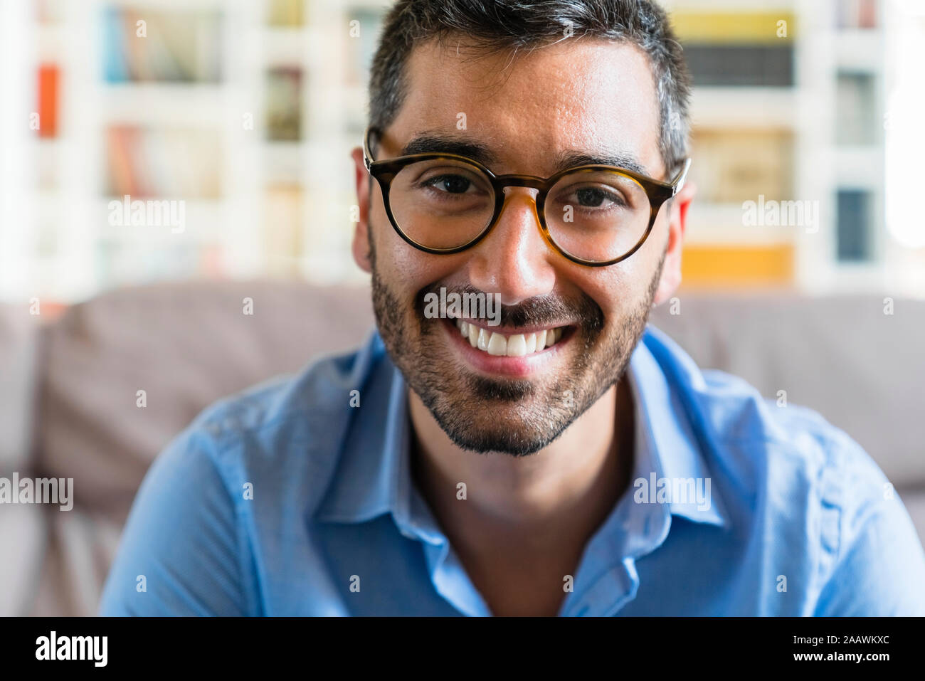 Portrait of happy young man wearing glasses  at home Stock Photo