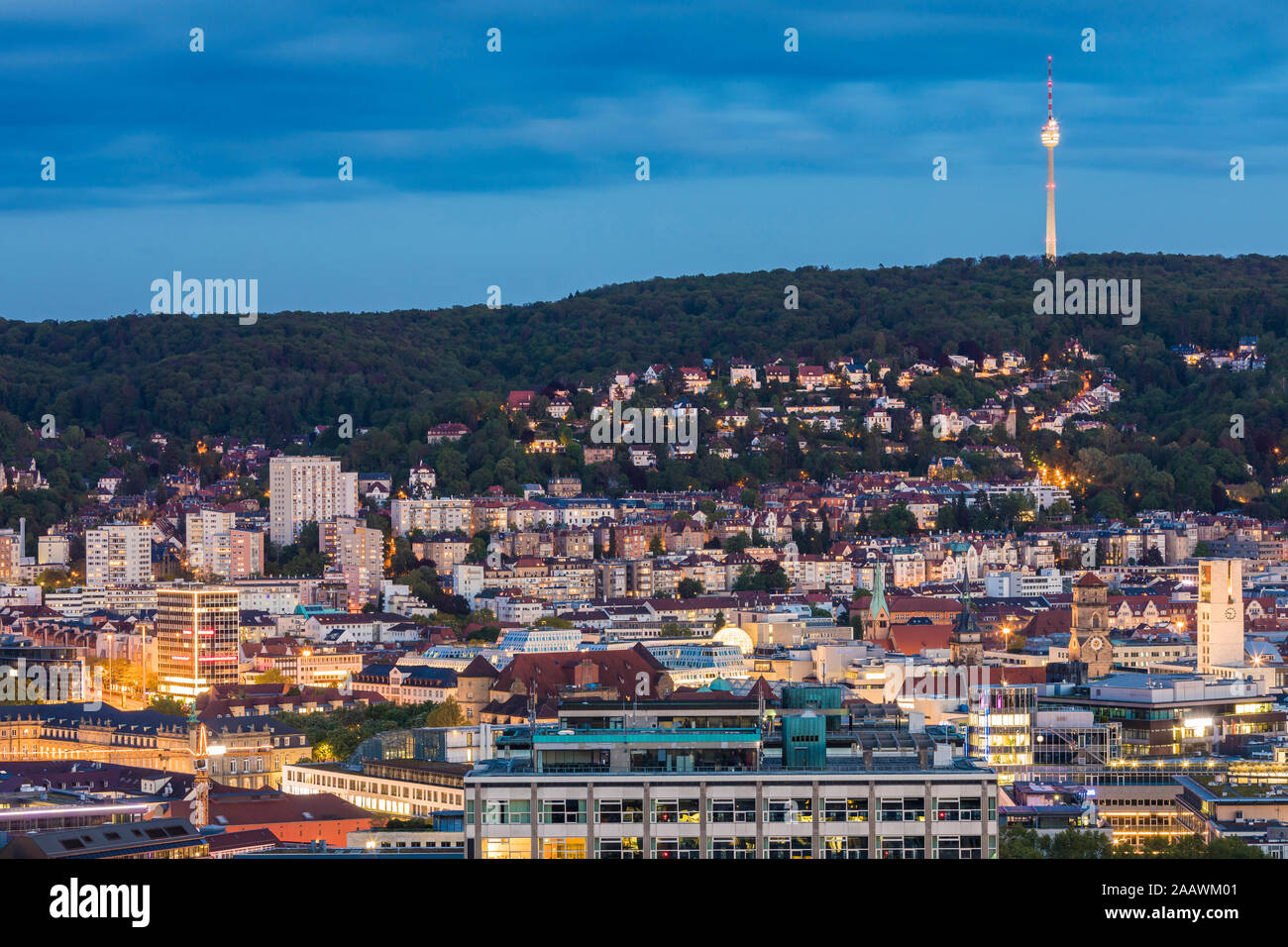 Exterior of illuminated buildings and communications tower against sky at dusk in Stuttgart, Germany Stock Photo