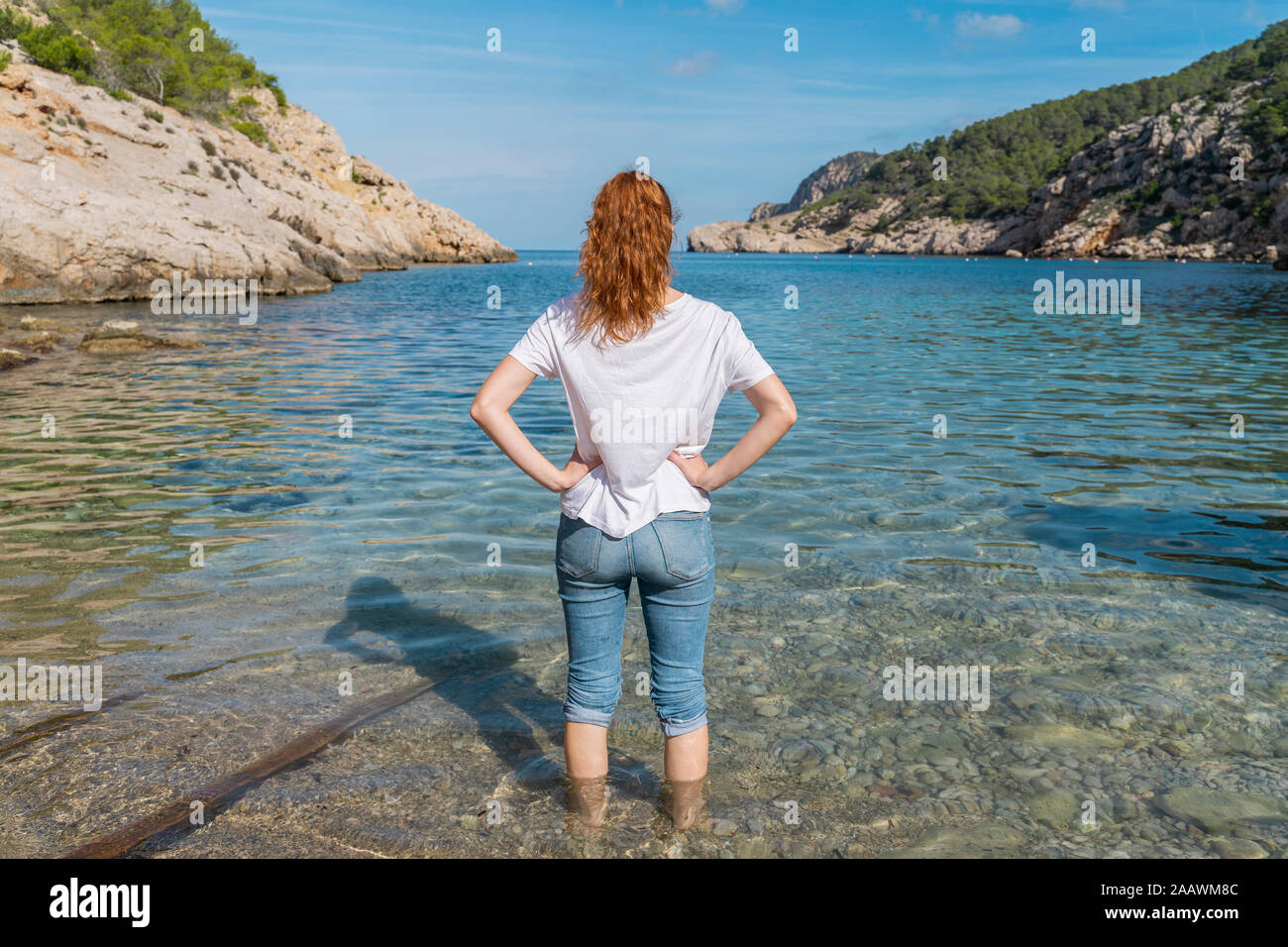 Young woman standing in water at the beach Stock Photo - Alamy