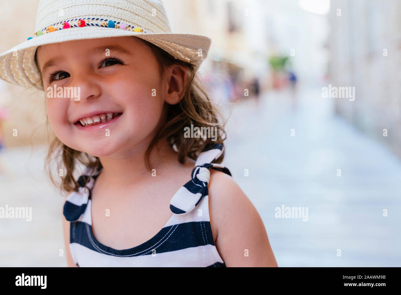 Portrait of laughing little girl wearing straw hat Stock Photo