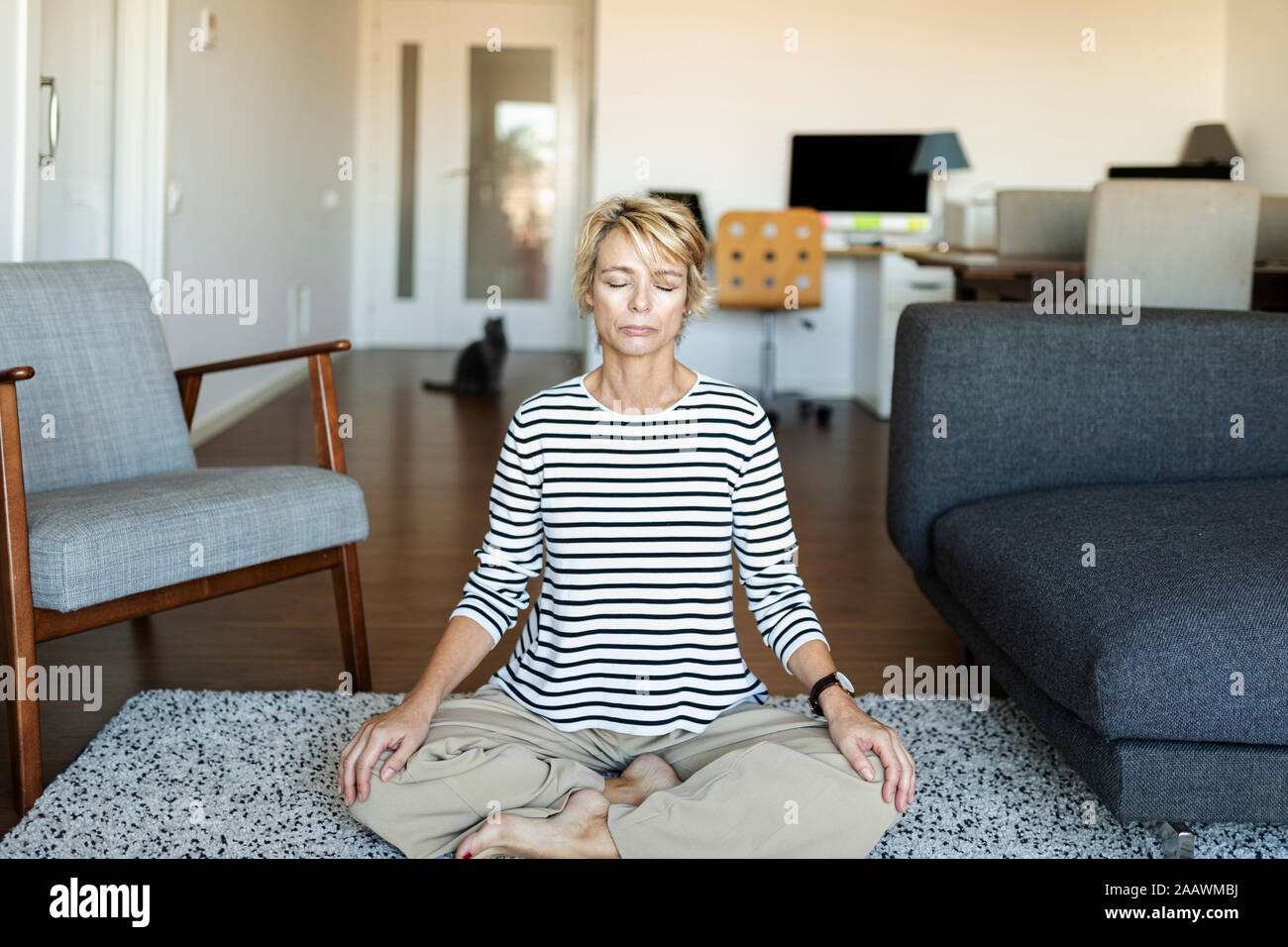 Mature woman practicing yoga at home Stock Photo