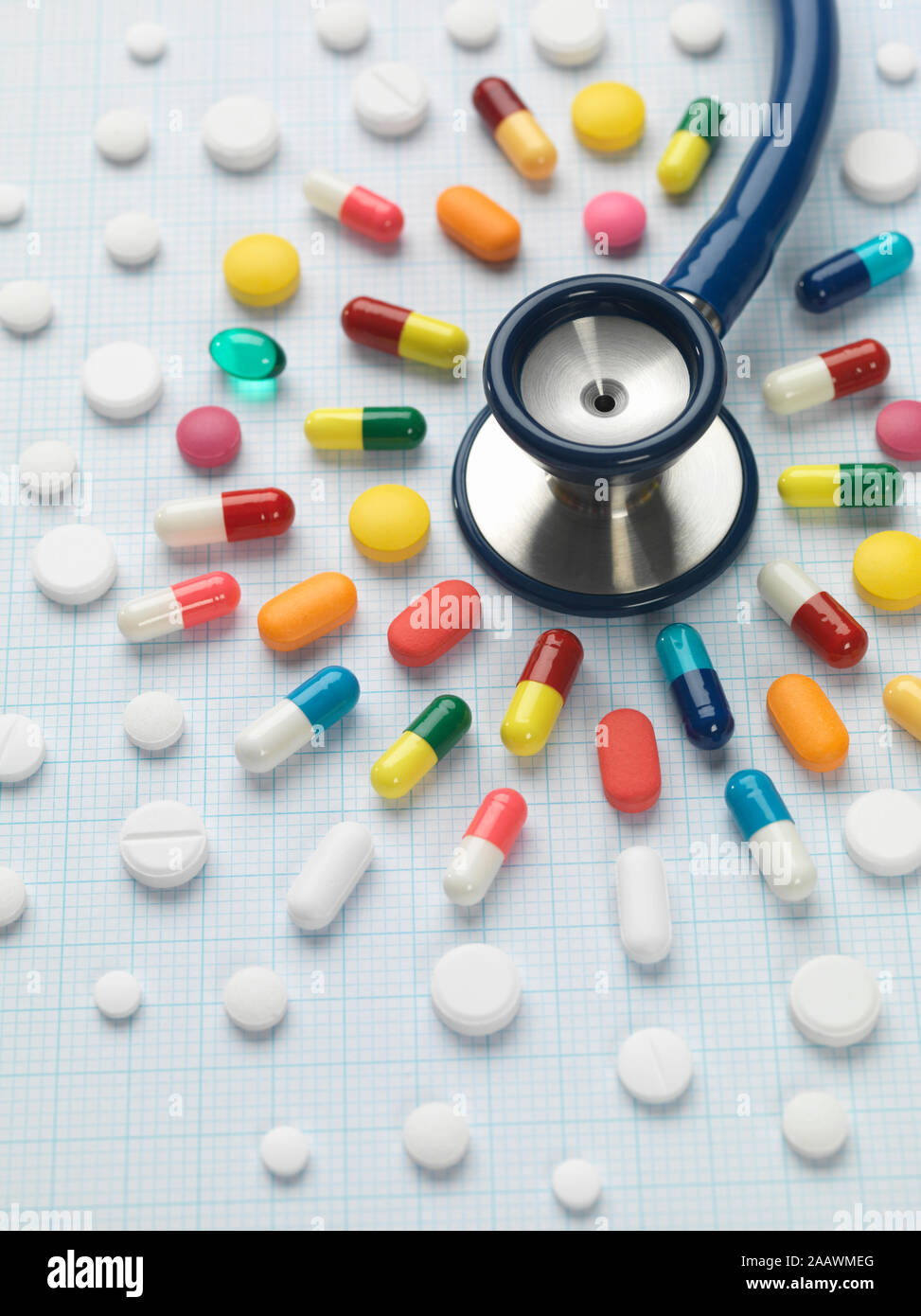 High angle view of various medicines arranged around stethoscope on graph paper Stock Photo