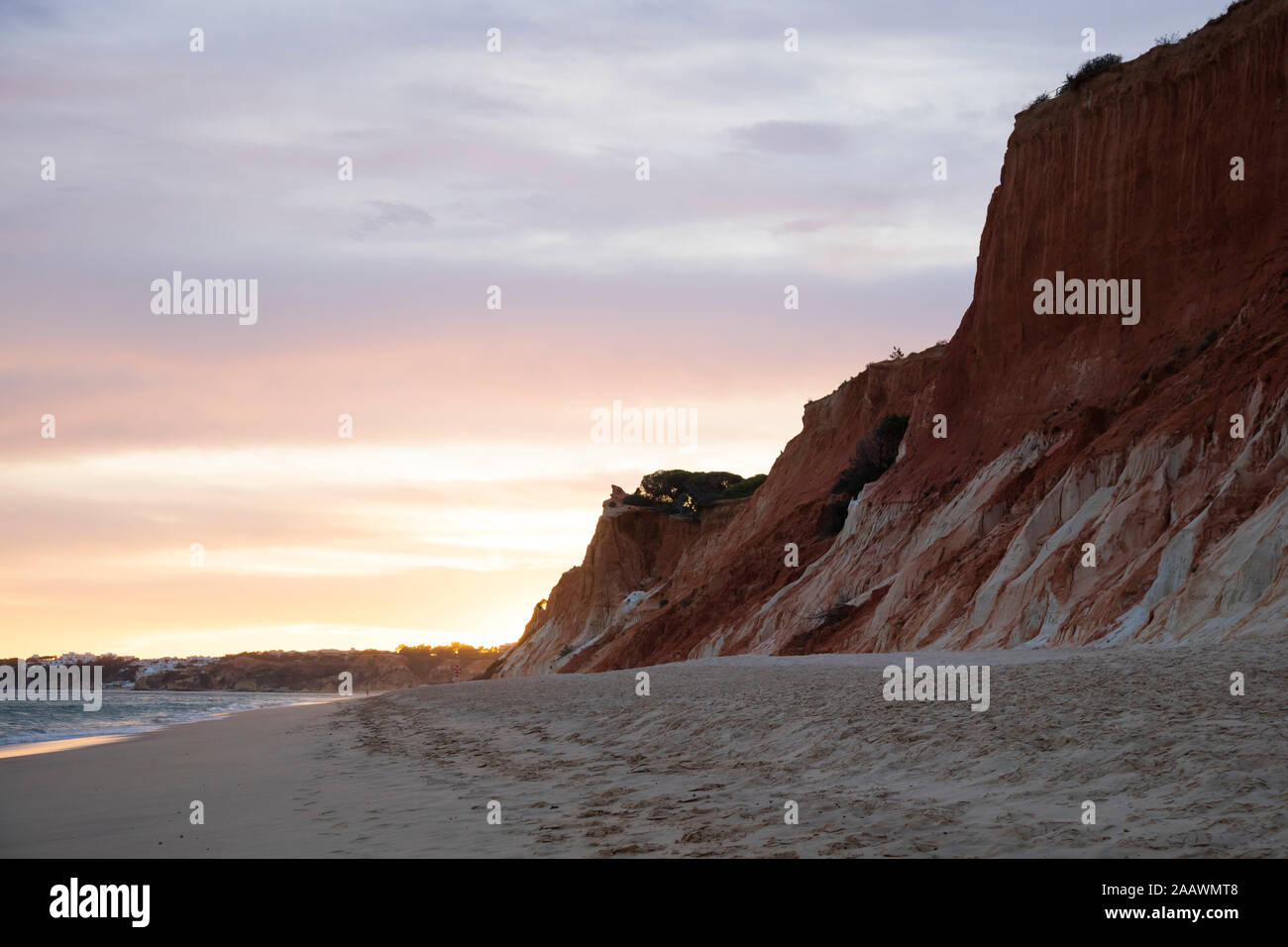 Rocky sandstone at Atlantic Coast against cloudy sky during sunset, Algarve, Portugal Stock Photo