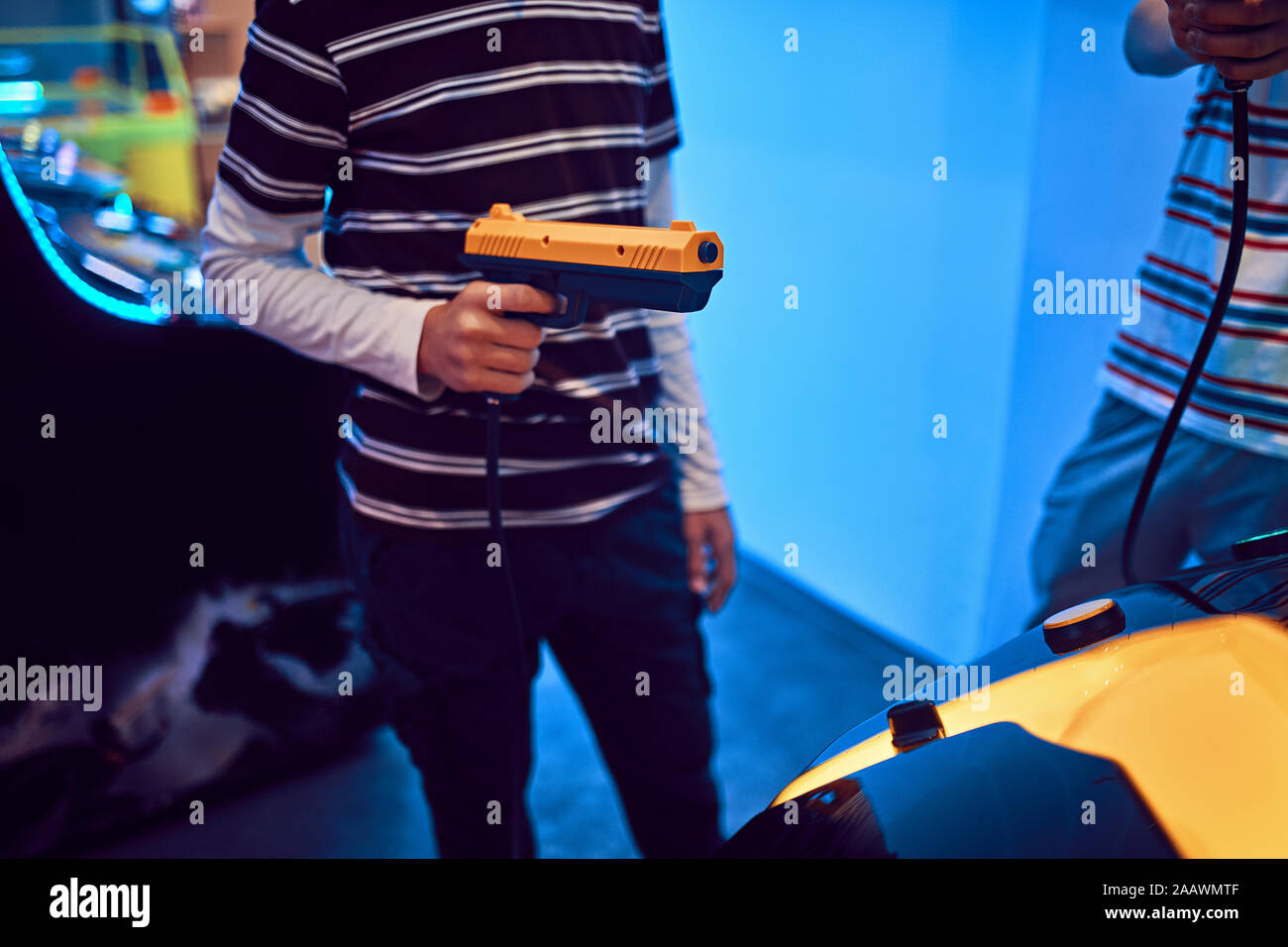 Close-up of teenage boy shooting with pistol in an amusement arcade Stock Photo