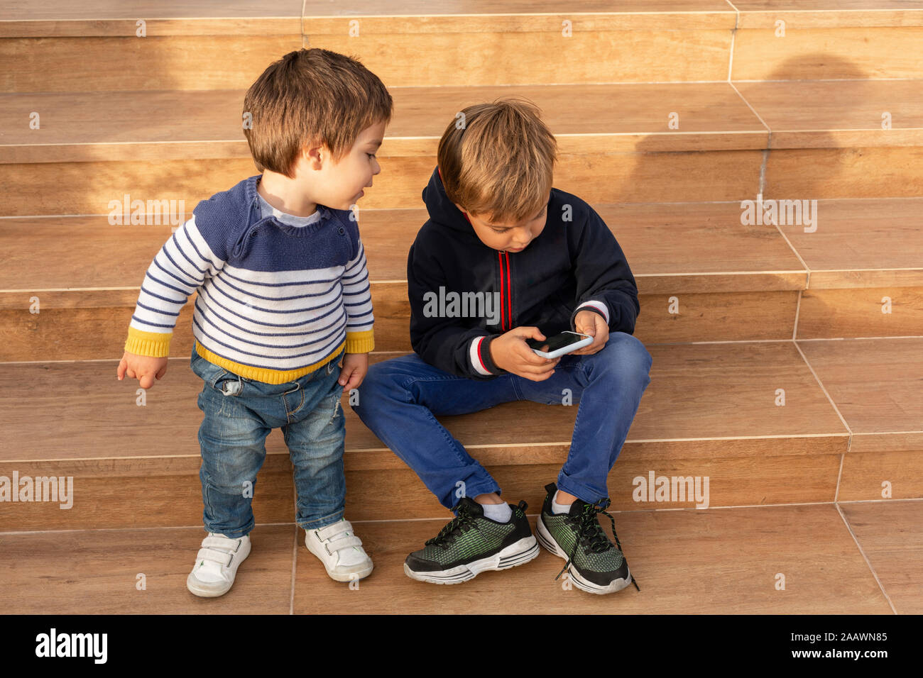 Two little boys looking at cell phone Stock Photo