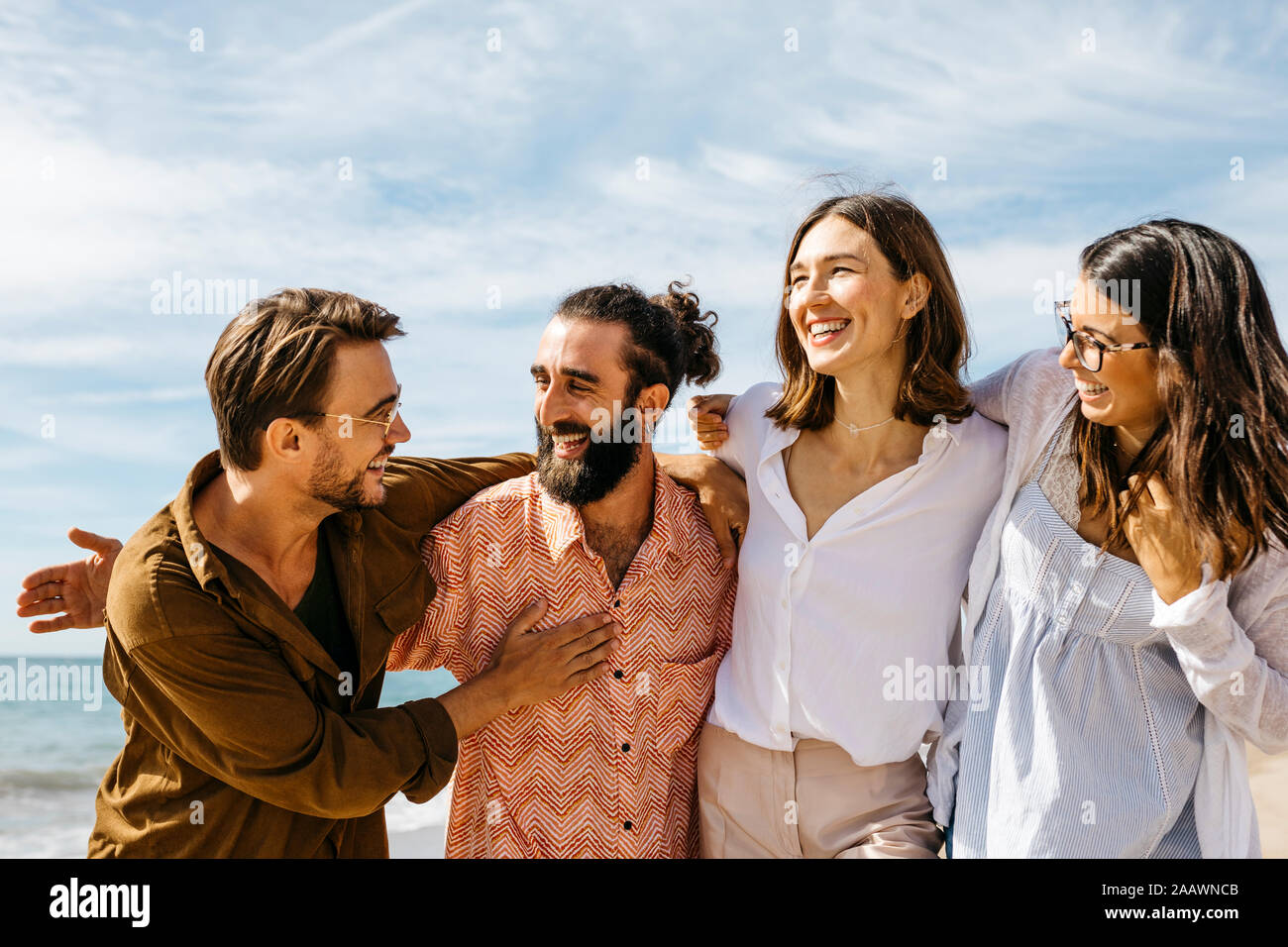 Happy friends embracing on the beach Stock Photo