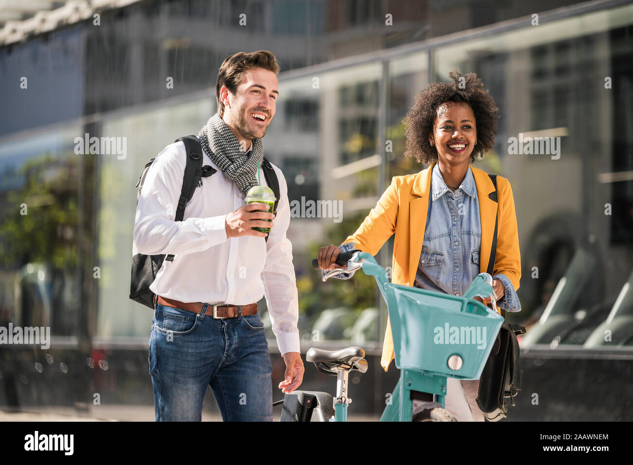 Happy young man and woman with bicycle in the city on the go Stock Photo