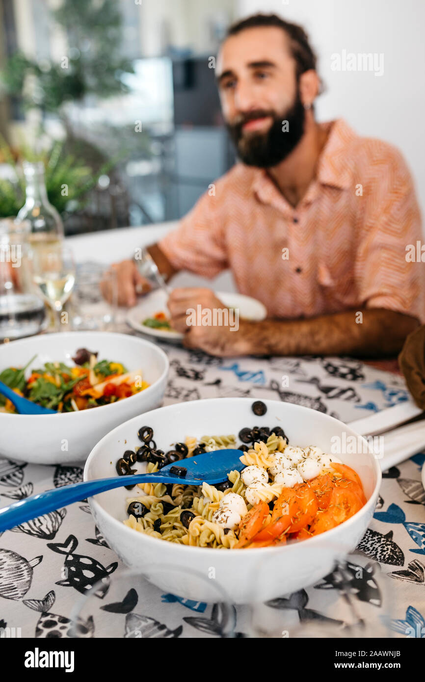 Smiling man sitting at dining table having healthy lunch Stock Photo