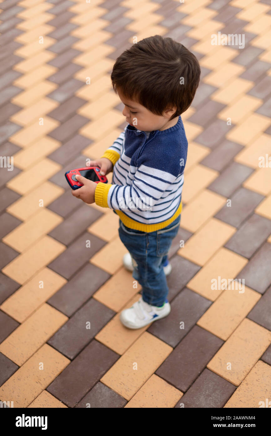 Little boy playing with toy mobile phone Stock Photo