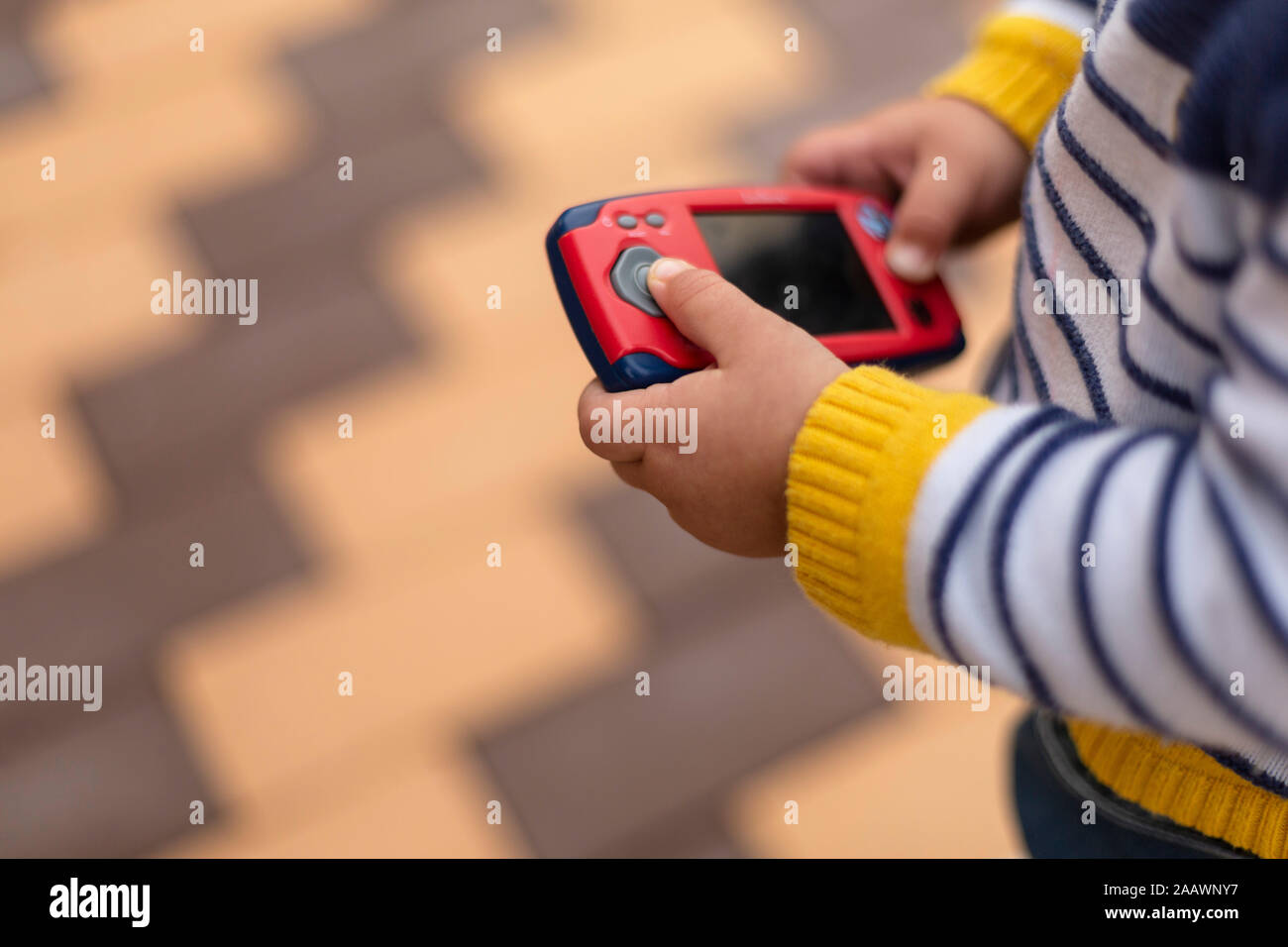 Hands of little boy holding toy mobile phone, close-up Stock Photo