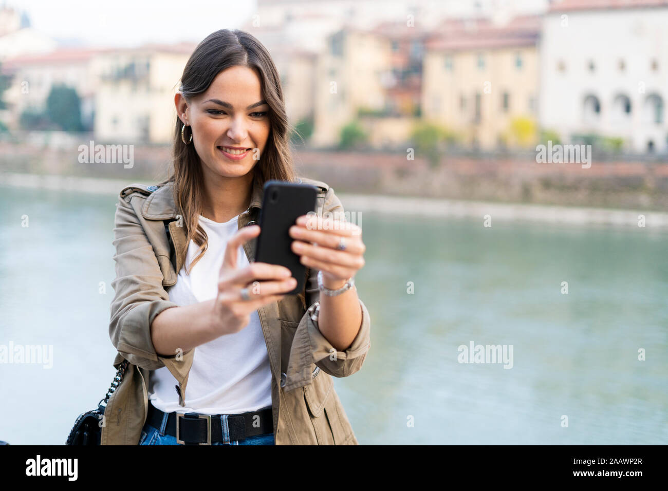 Young brunette woman using smartphone in Verona, Italy Stock Photo