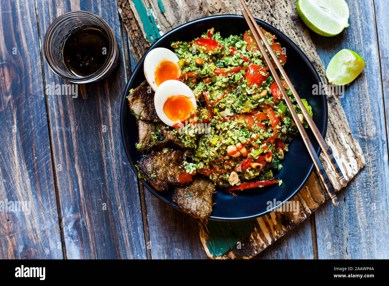 Thai style fried broccoli rice (shredded broccoli) with beef slices, eggs, and spicy sauce (ketogenic diet, paleo diet, low carb) Stock Photo