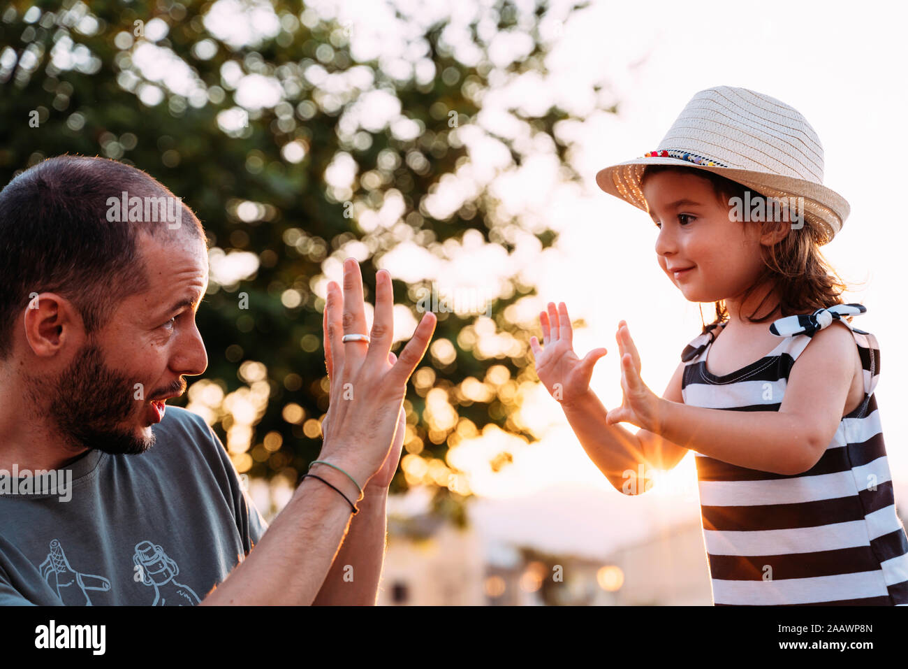 Father and little daughter playing together at sunset Stock Photo