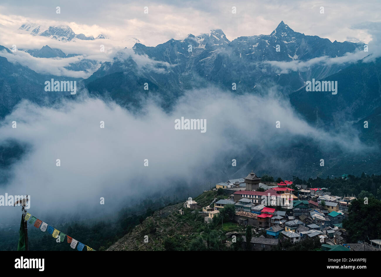 Kalpa, Himachal Pradesh, India. Elevated view of Kalpa village dwarfed by the snow capped Himalayas under blue sky at dawn in Kalpa, Himachal Pradesh, Stock Photo