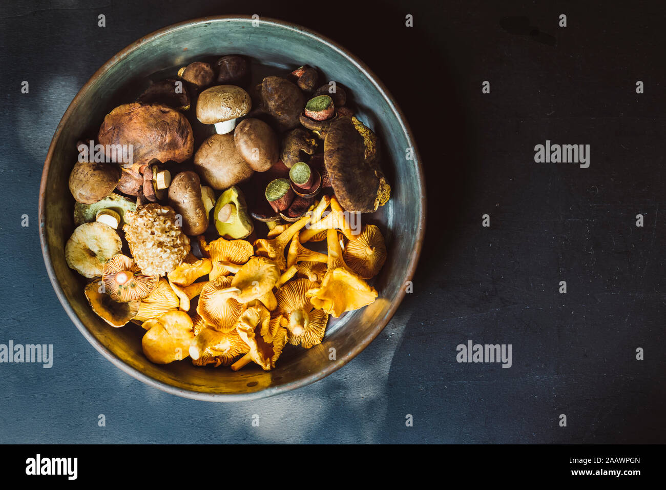 Directly above shot of various mushrooms in container on table Stock Photo