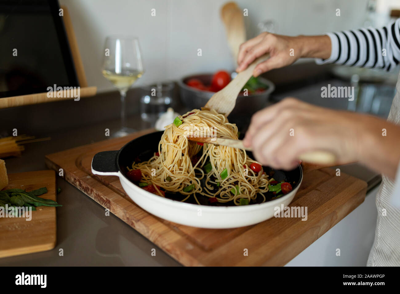 Close-up of woman cooking pasta dish in kitchen at home Stock Photo
