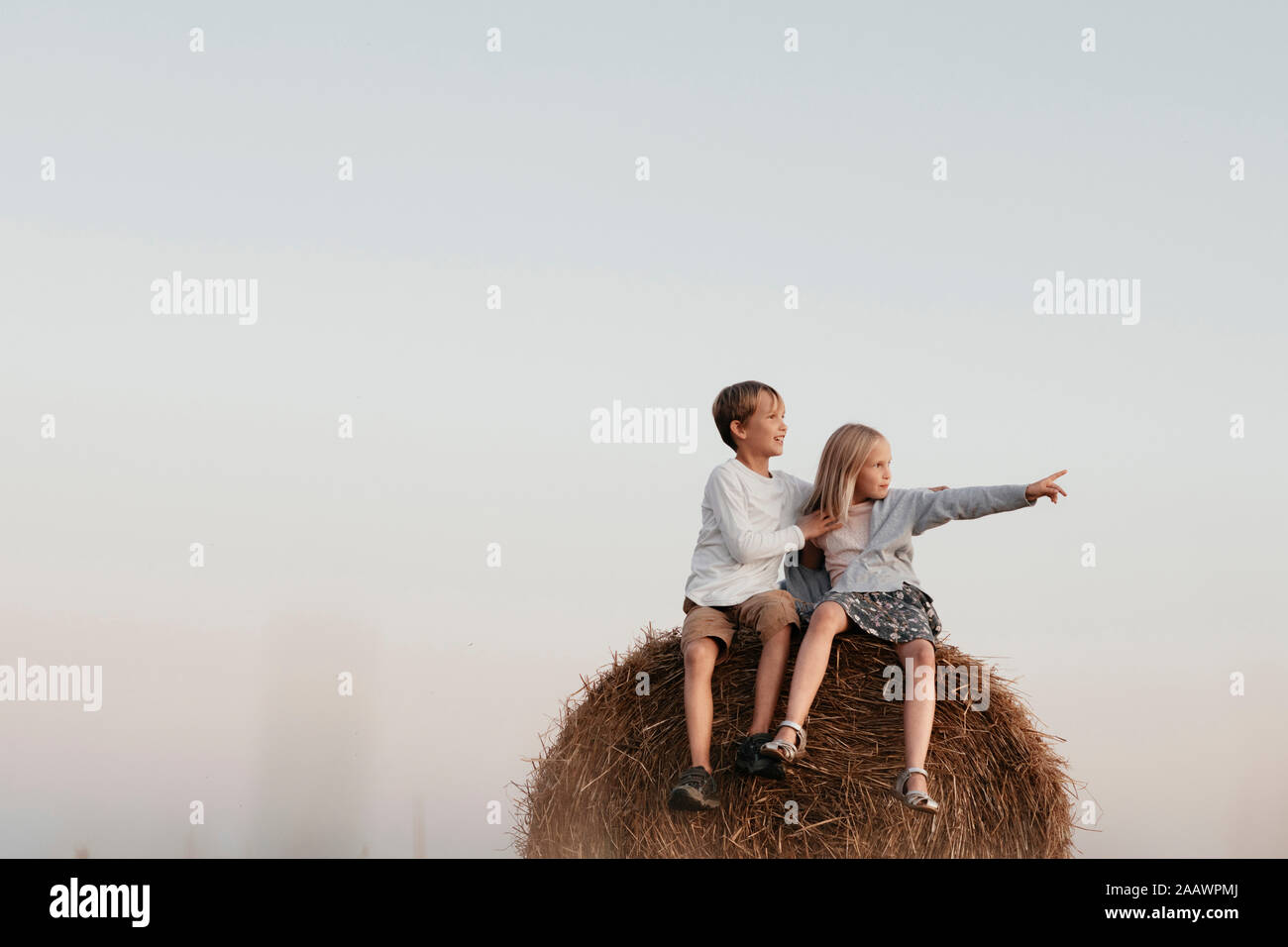 Two kids sitting on the haystack Stock Photo