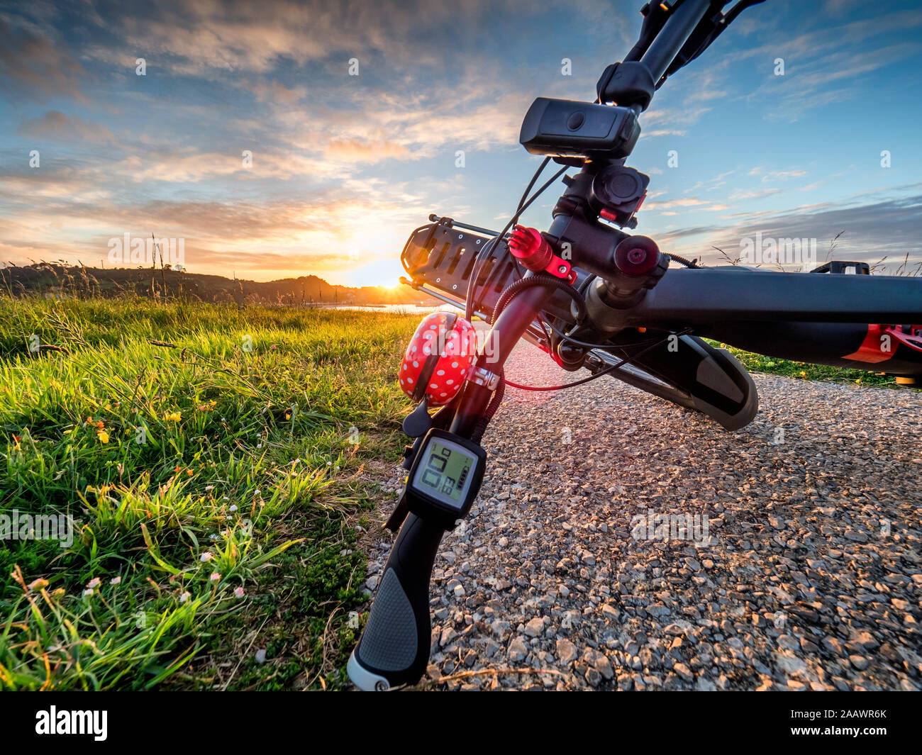 Bicycle fallen on road against sky during sunset, Perlora, Spain Stock Photo