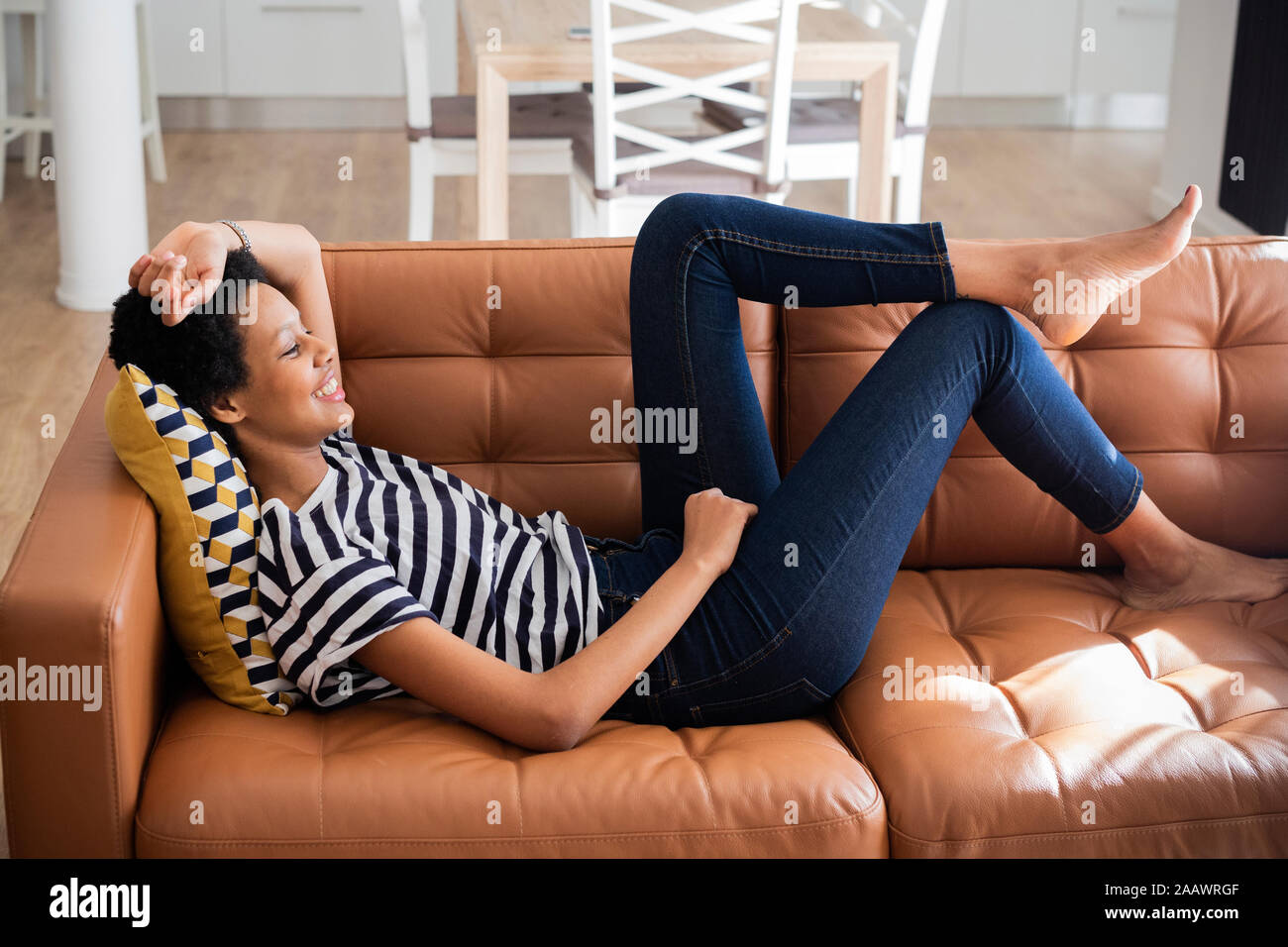 Relaxed young woman lying on couch at home Stock Photo Alamy