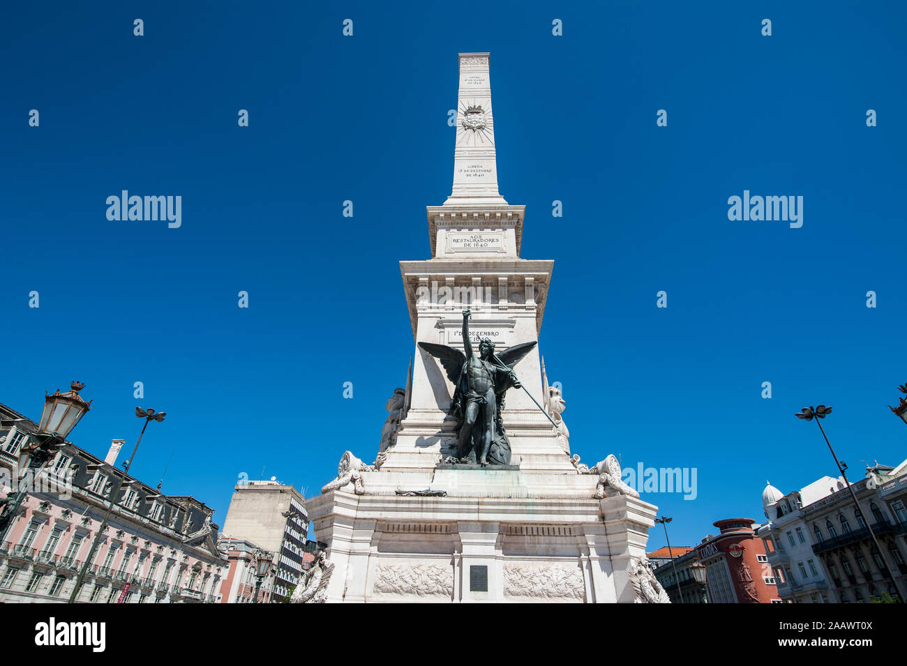 Low angle view of Monument to the Restorers against clear blue sky in Restauradores Square, Lisbon, Portugal Stock Photo
