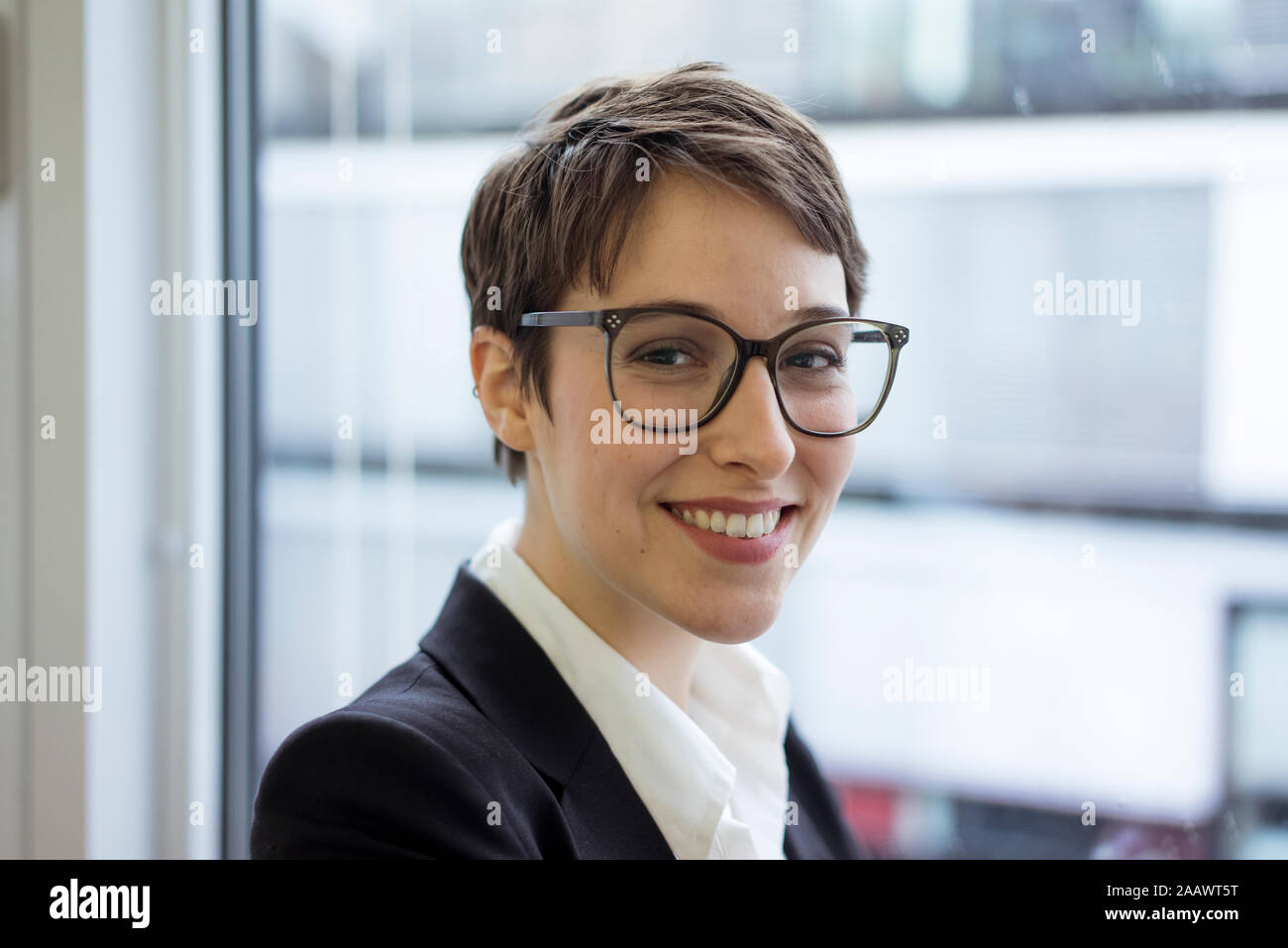Portait of smiling young businesswoman at the window Stock Photo