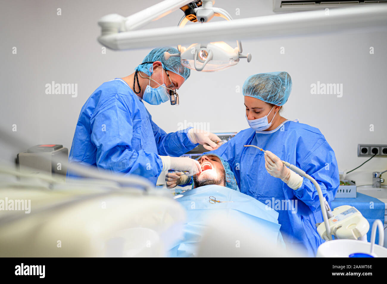 Dental surgeon and assistant work putting dental implant Stock Photo