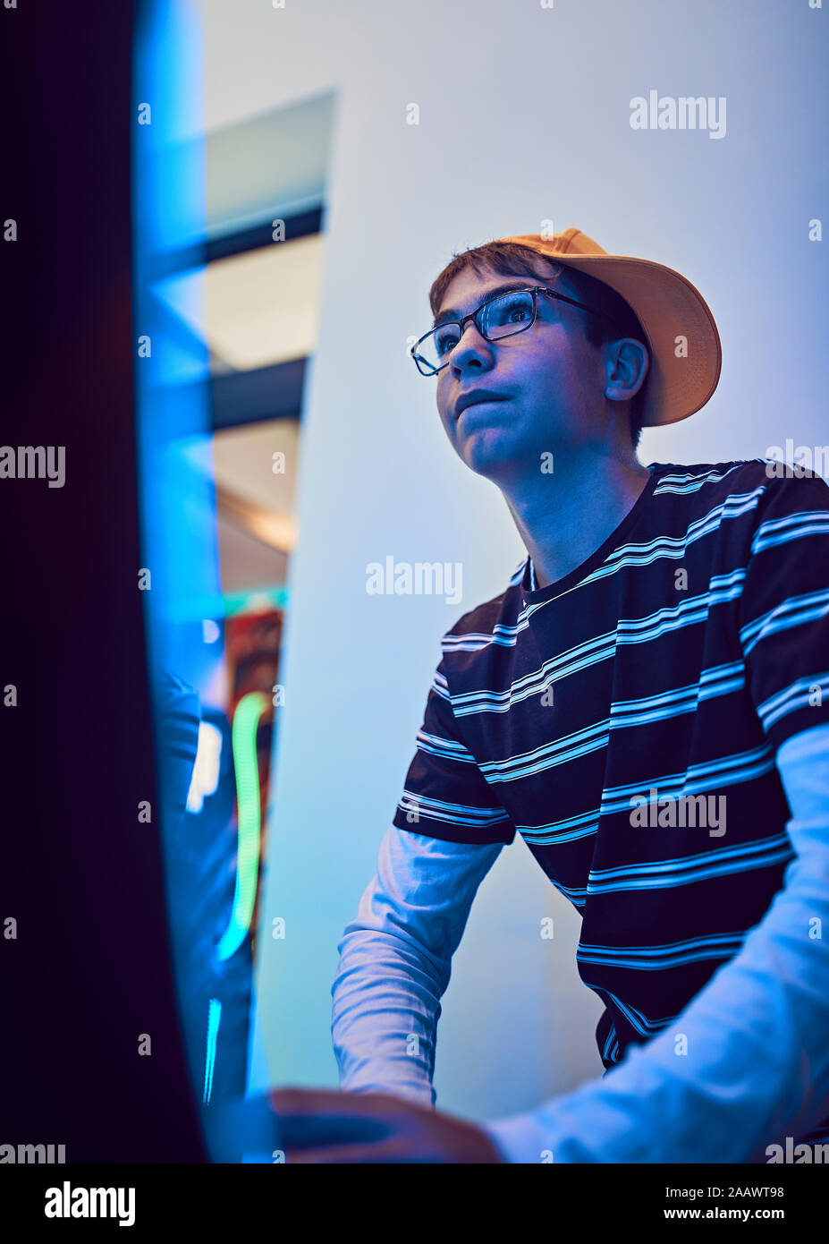 Teenage boy playing with a gaming machine in an amusement arcade Stock Photo