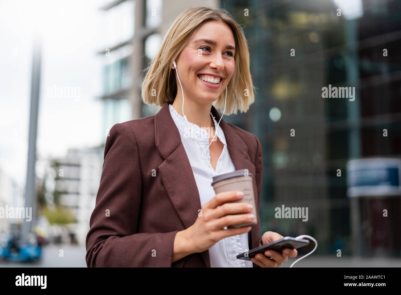 Happy young businesswoman in the city on the go Stock Photo