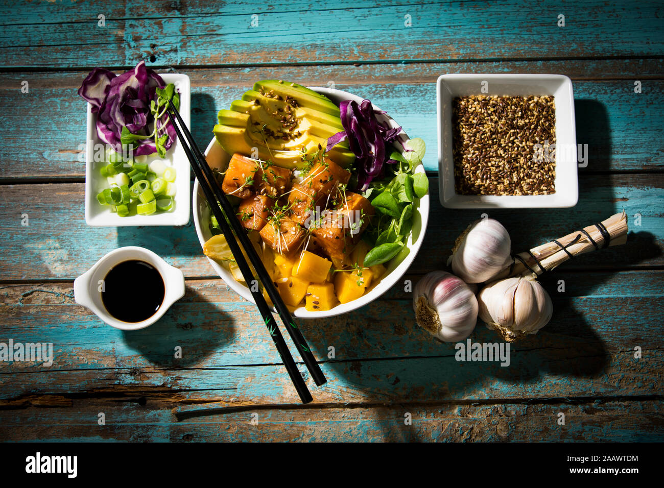 High angle view of poke bowl with ingredients on wooden table Stock Photo
