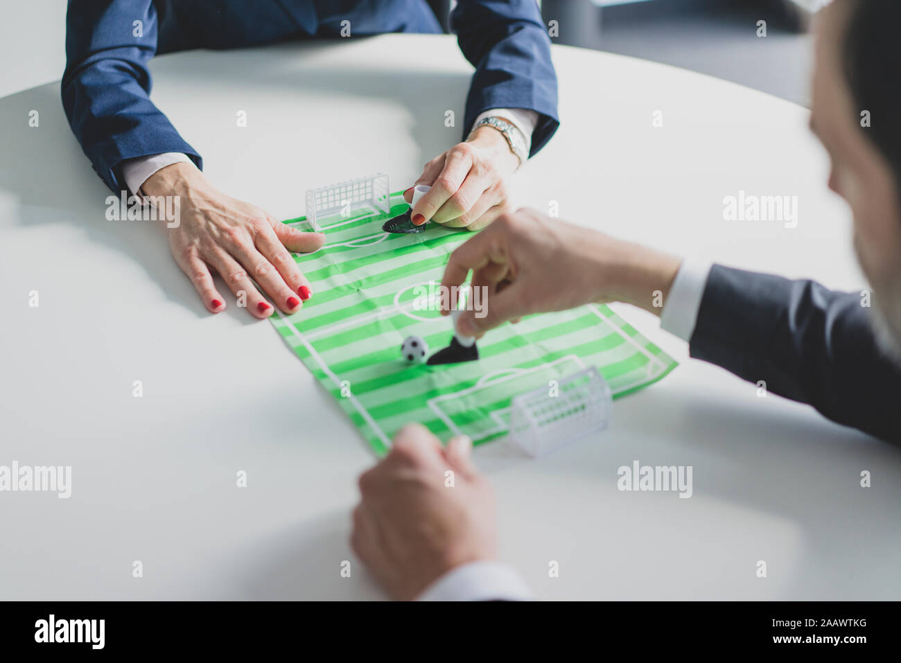 Close-up of businesswoman and businessman playing table football in office Stock Photo