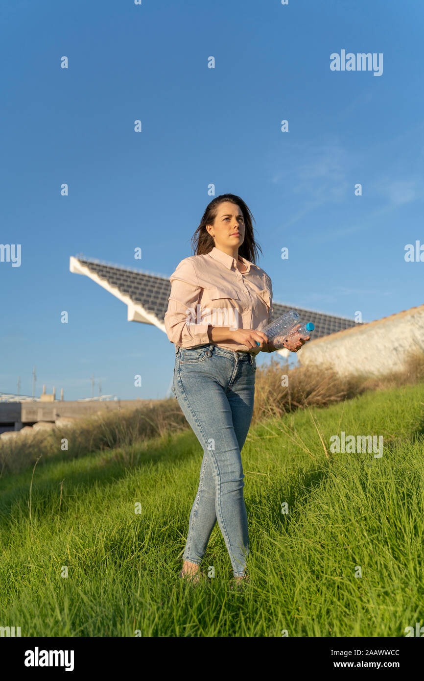 Woman's on a meadow with two empty empty plastic bottles Stock Photo