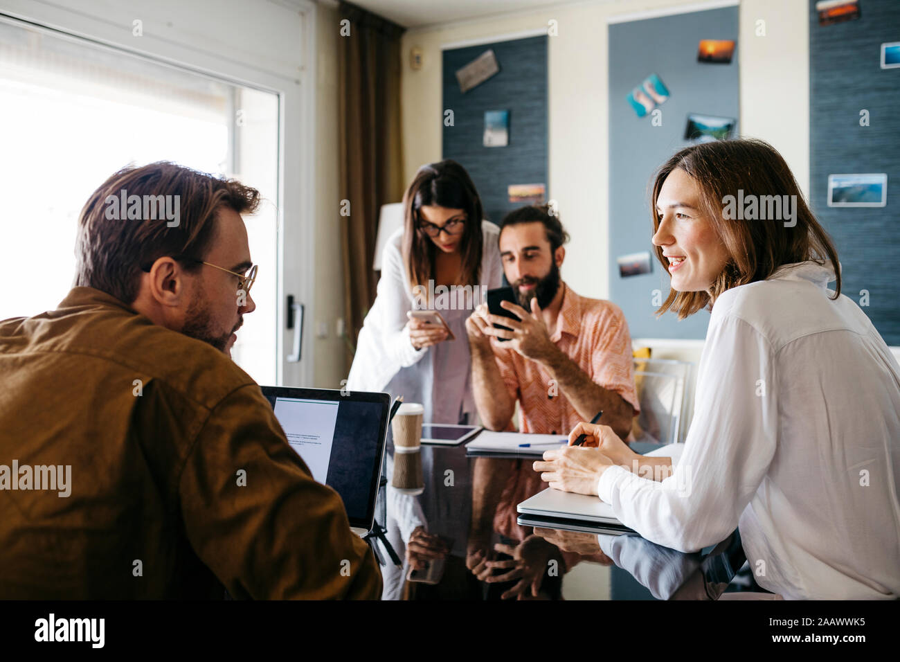 Friends working together on table at home talking Stock Photo